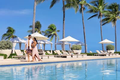 Couple walking by pool at Hilton Rose Hall, an all-inclusive resort.