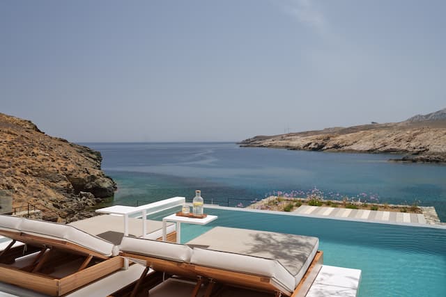 Private pool with loungers and drinks overlooking sea view