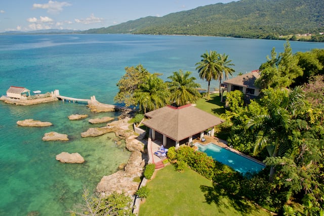 Bluefields Bay Villas Hotel Exterior by the Water with Mountains in Background