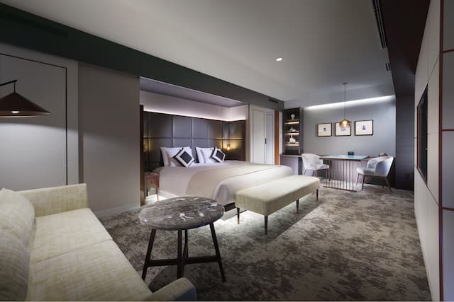 Large Bed, Sofa and Sitting Area in a Deluxe Guest Room