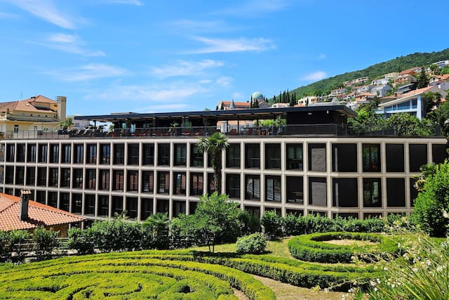 Hotel exterior with surrounding buildings and bushes