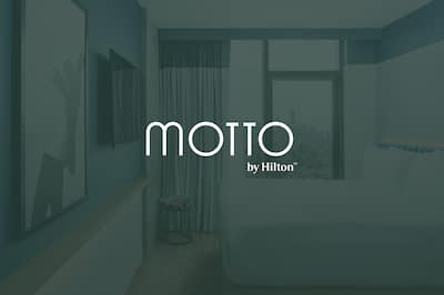 King Bedroom with the Motto by Hilton logo on top of the image