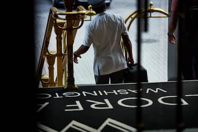 Woman walking down stairs with luggage in hand