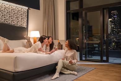 Group of women relaxing in guest room with champagne