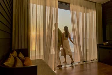 Man and woman stepping through net curtain onto outdoor area