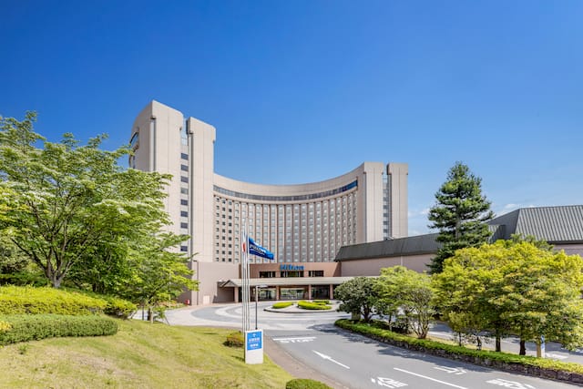 Hilton Hotel Exterior with Trees and Flags at the Entrance