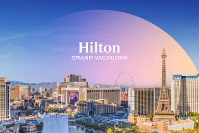 A Hilton Grand Vacations logo floating over the Las Vegas strip on a sunny day