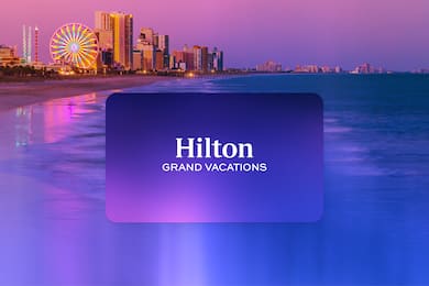 A Hilton Grand Vacations logo over a sunset on Myrtle Beach pier