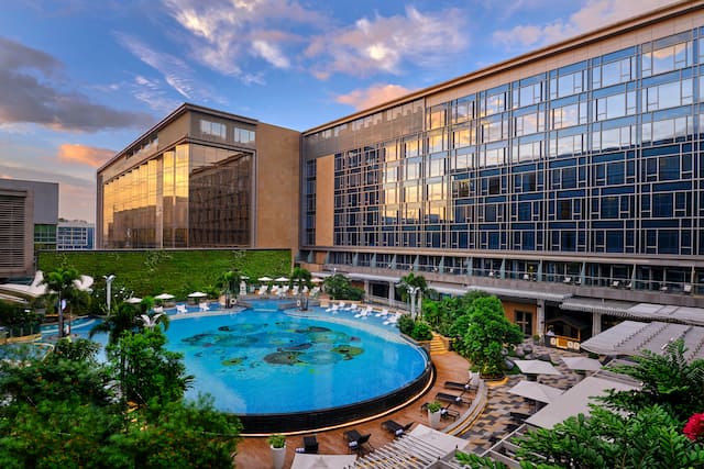 Hotel Exterior with Outdoor Pool and Lounge Area