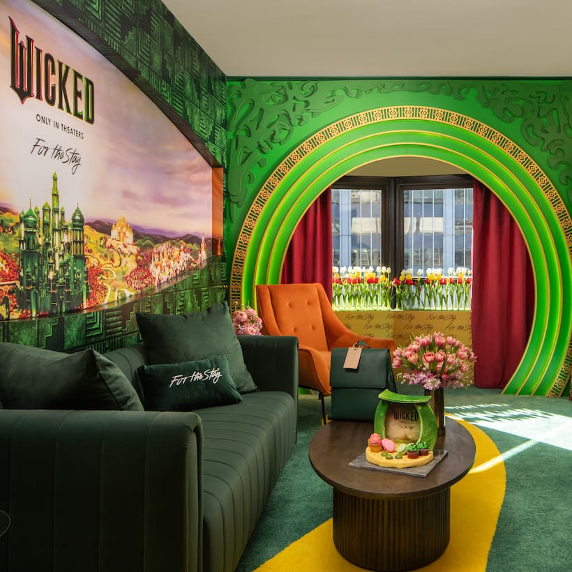 A delightful tribute to the new Wicked film, the living room of the suite brings to life the magic of the Emerald City.