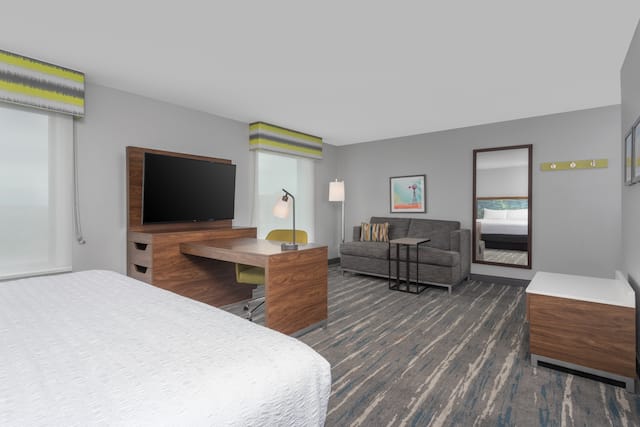 Guestroom lounge area with sofa and TV