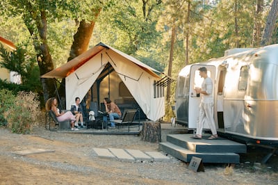Static home with tent, and people relaxing