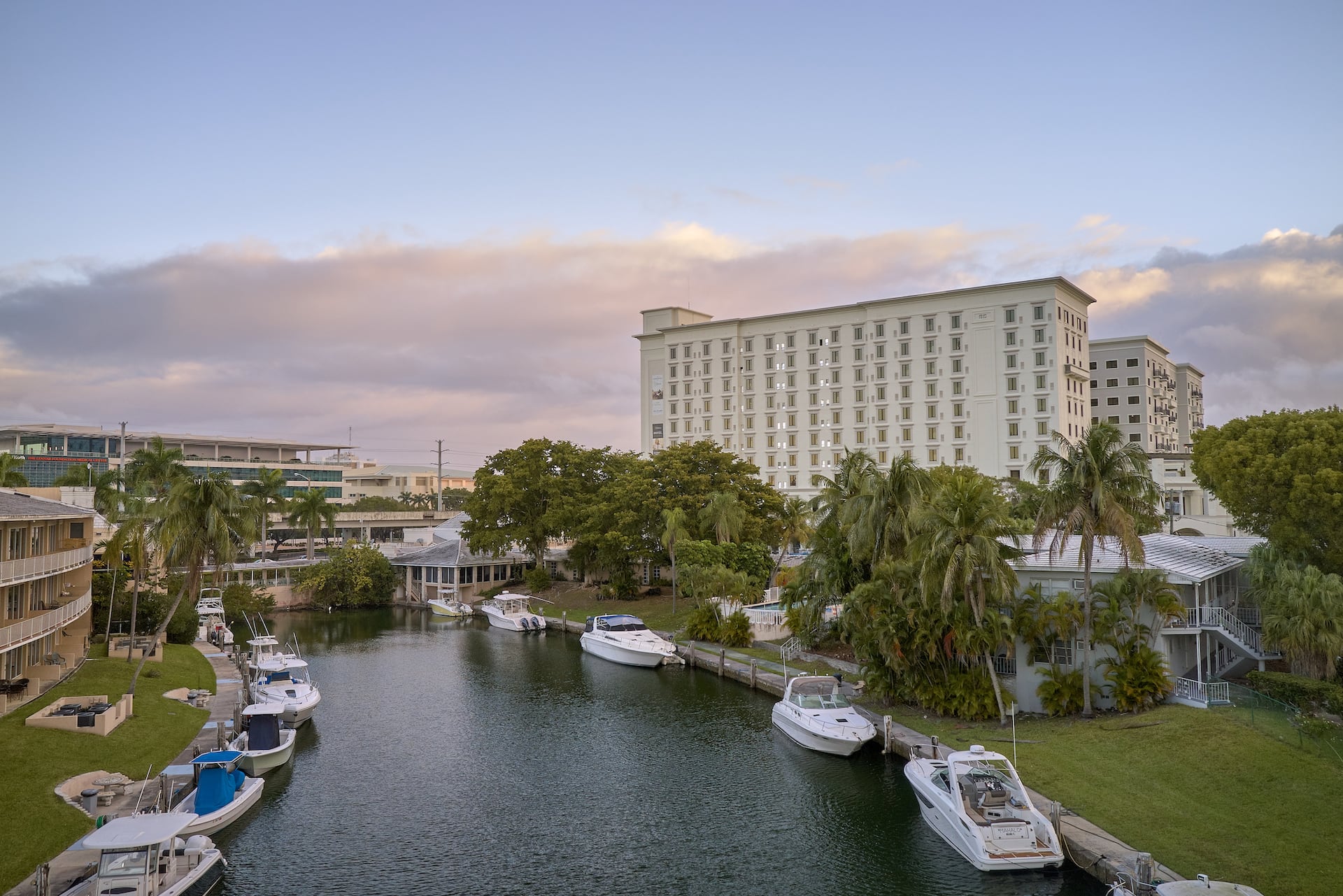 Boats moored along a canal with the hotel building in the background