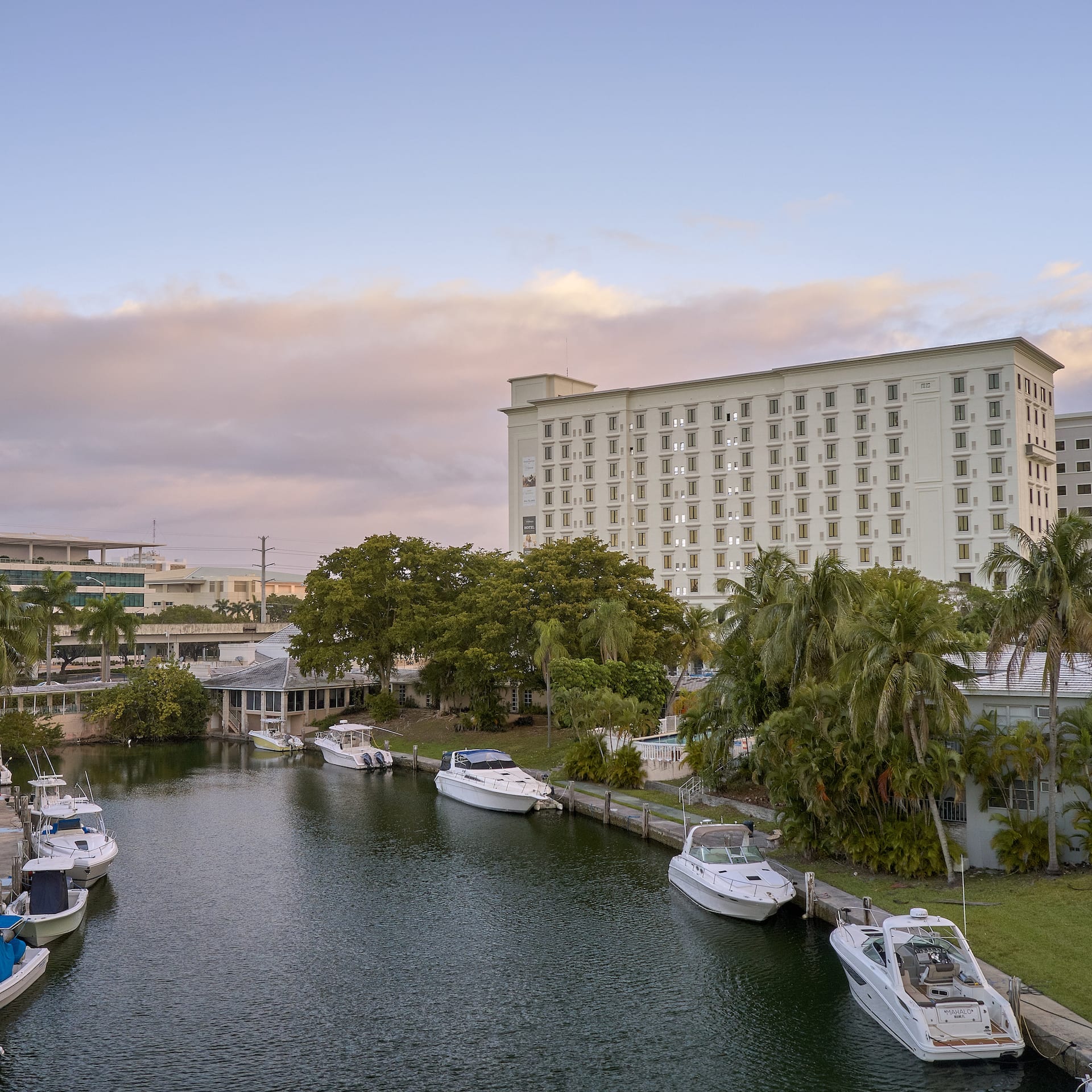 Boats moored along a canal with the hotel building in the background