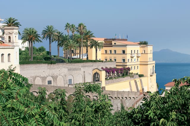 Hotel Exterior by the Sea and View of Mountains in the Distance