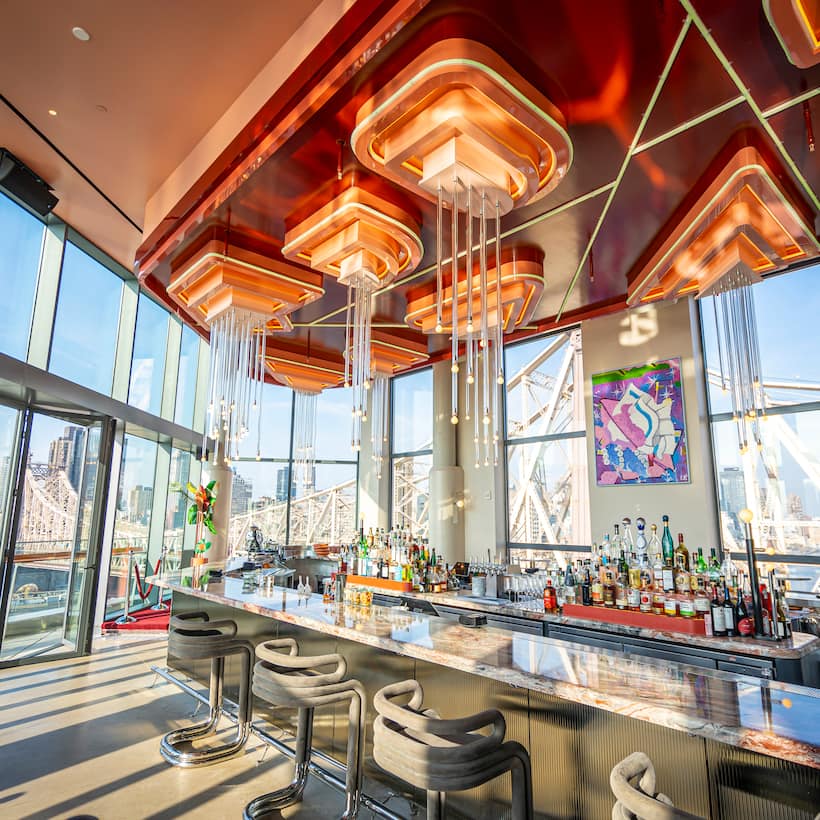 Internal view of bar and skyline behind floor to ceiling windows at Panorama Room, New York.