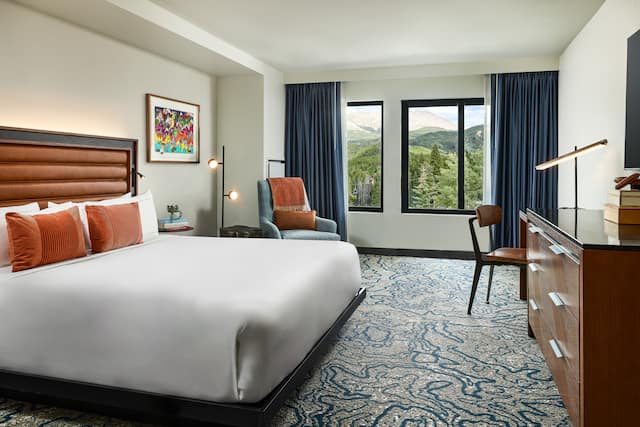 Guestroom with bed and chair next to window