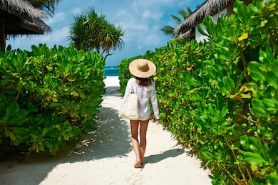 Woman walking on path to beach