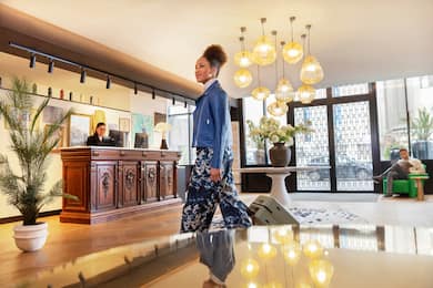 Woman walking through lobby area with luggage